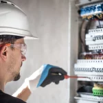 Técnico inspeccionando panel eléctrico con guantes de protección en Jaén